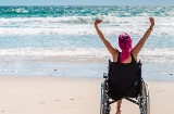 Turista en silla de ruedas disfrutando de la playa