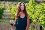 ブドウ畑でワイングラスを手に持つ女性