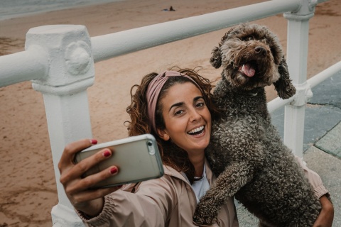  Turista fazendo uma selfie com seu animal de estimação em uma praia de Gijón, Astúrias