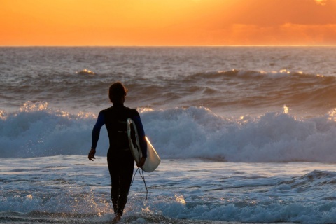 Surfista che contempla il tramonto a Fuerteventura, nelle isole Canarie