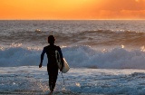 Surfer podziwiający zachód słońca na Fuerteventurze na Wyspach Kanaryjskich