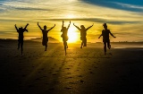 Grupka przyjaciół na plaży w Galicji o zachodzie słońca
