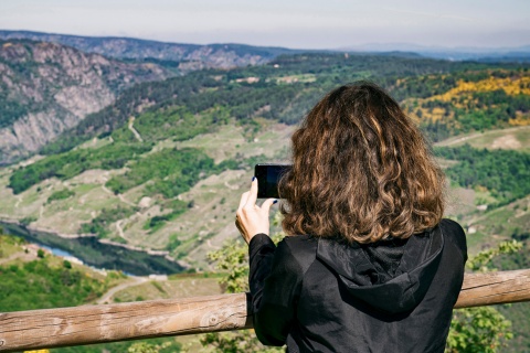 Tourist, der die Landschaft von einem Aussichtspunkt in der Ribeira Sacra fotografiert