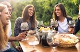 Друзья поднимают бокалы с красным вином