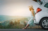 Turista apoyada en el coche descansando de su viaje en carretera