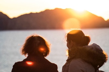  Junge Frauen betrachten den Sonnenuntergang auf den Cíes-Inseln