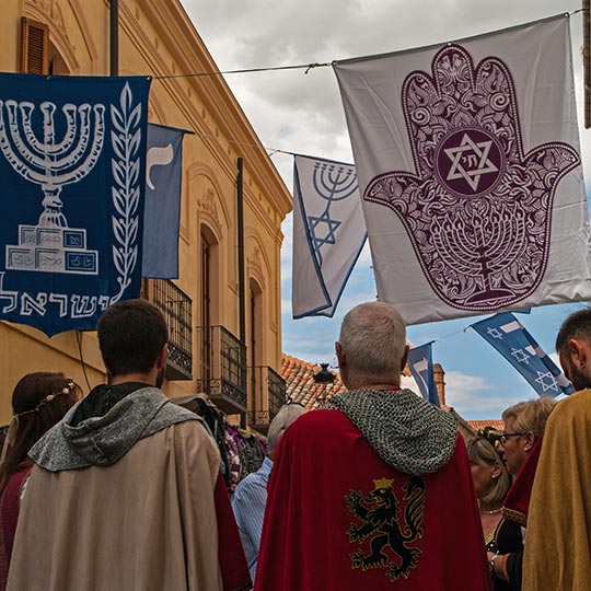 Przebrani za rycerzy z żydowskimi emblematami na średniowiecznym festiwalu w Avila w dzielnicy żydowskiej