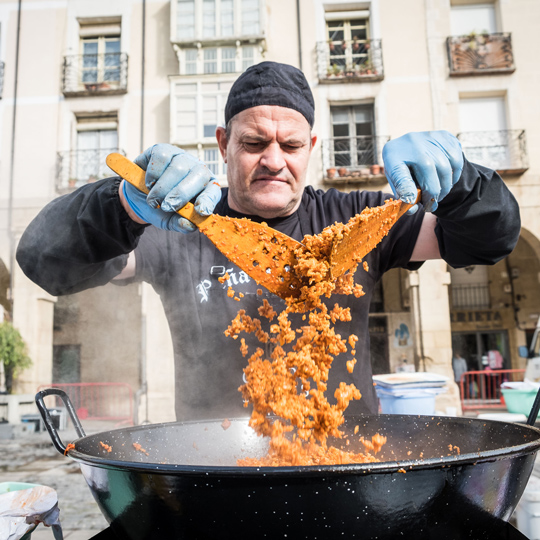 Membro di un'associazione che prepara il tipico piatto delle migas durante le Feste della vendemmia della Rioja a Logroño, La Rioja