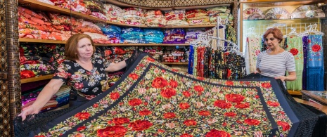 Una donna che acquista uno scialle di Manila in un negozio di Siviglia