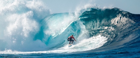 Un ragazzo solca una grande onda a El Quemao a Lanzarote, isole Canarie