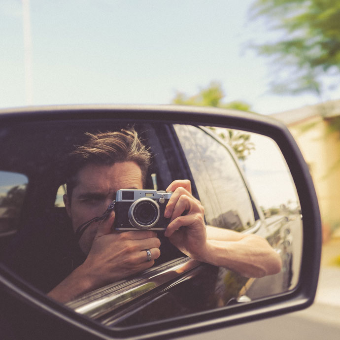 Jeune homme en voiture avec un appareil photo