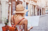 Una turista passeggia per la città con una cartina