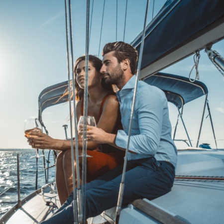 Couple enjoying a glass of wine on a boat off Menorca, Balearic Islands