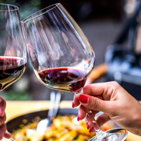 Тост с красным вином на фоне паэльи.