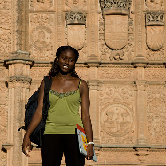Student by the façade of the University of Salamanca