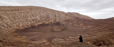 Un turista contempla il vulcano della Caldera Blanca a Lanzarote, isole Canarie